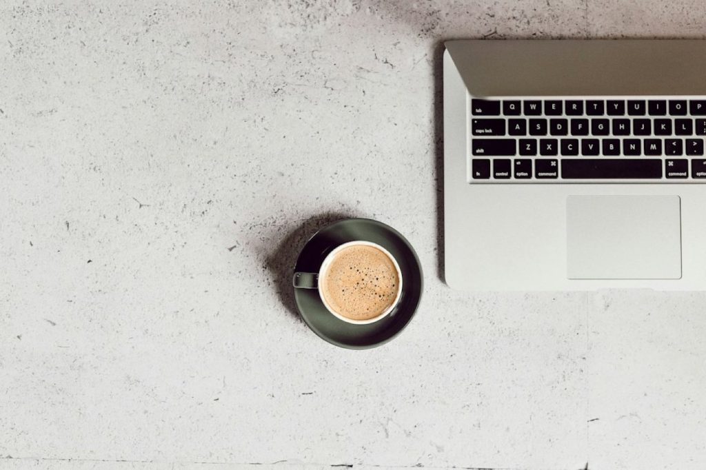 Ordinateur portable et café sur un bureau clair