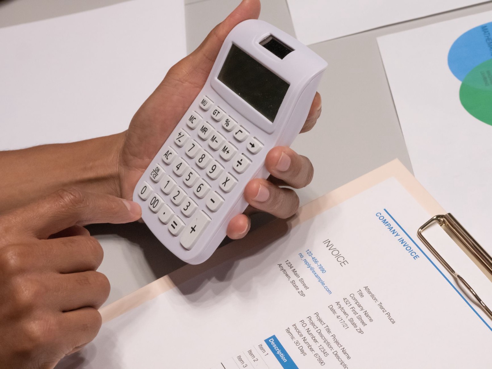 Facture papier posée sur un bureau à côté d'une calculatrice et d'un stylo