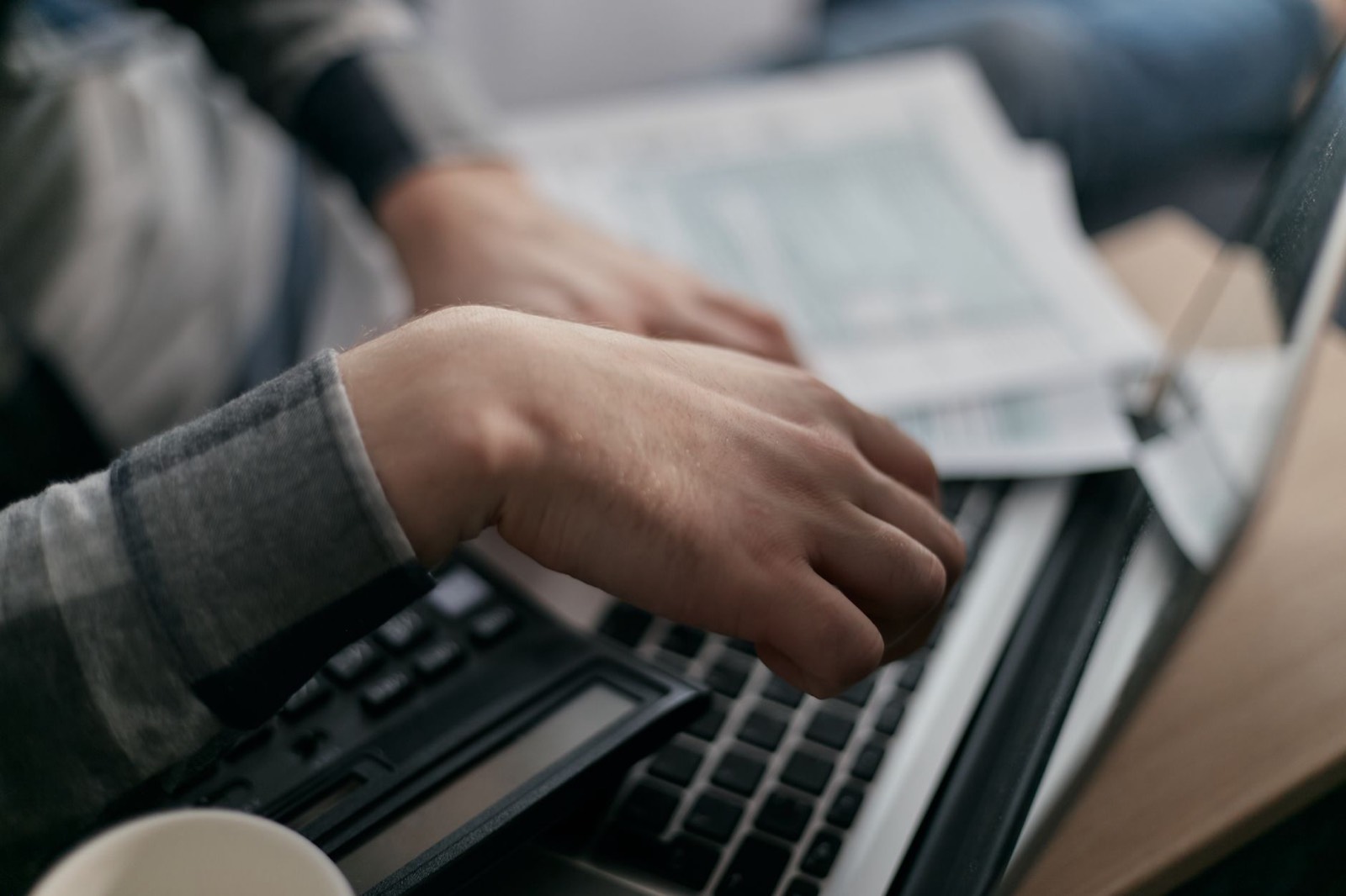 Une facture affichée sur l'écran d'un ordinateur portable, à côté d'un carnet de notes