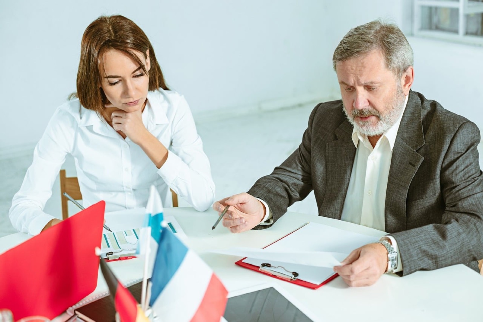 Webdesigner présentant une maquette de site à son client devant un écran